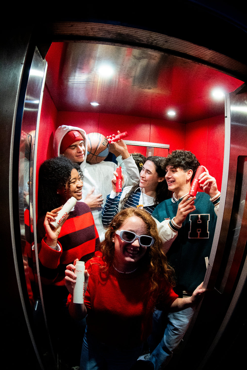 Group of people in a red-lit elevator with prereq