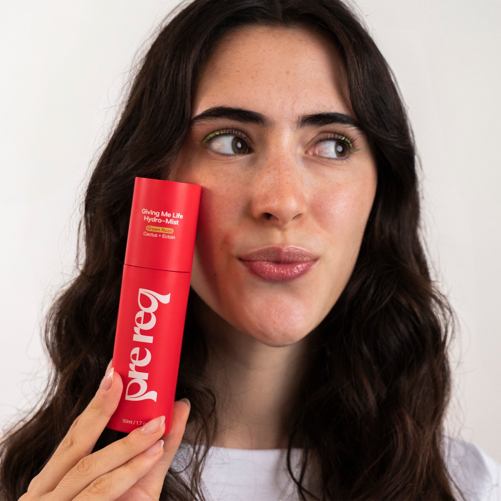 Woman holding a red 'pre req' product against a white background