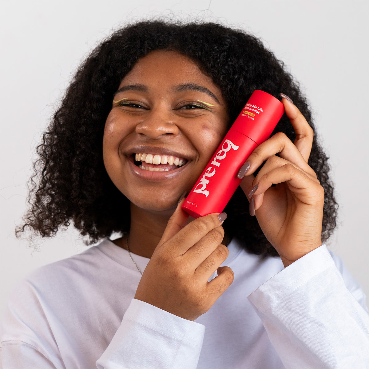 Person holding a red bottle with 'Prego' branding against a white background